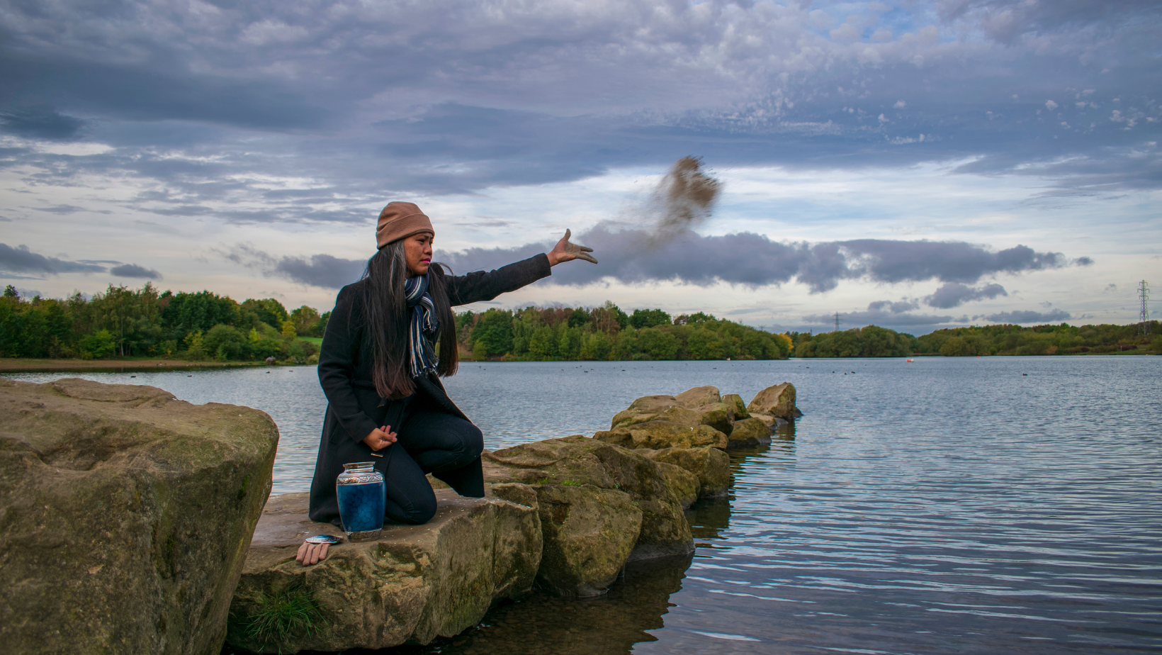 Woman throwing ashes into the water from an Urn