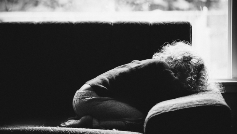 child with head down on couch